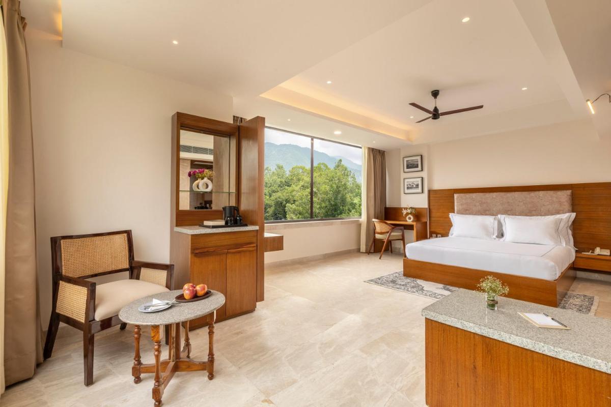 a hotel room with a bed and a desk at The Prominence Mussoorie Road Dehradun in Dehradun