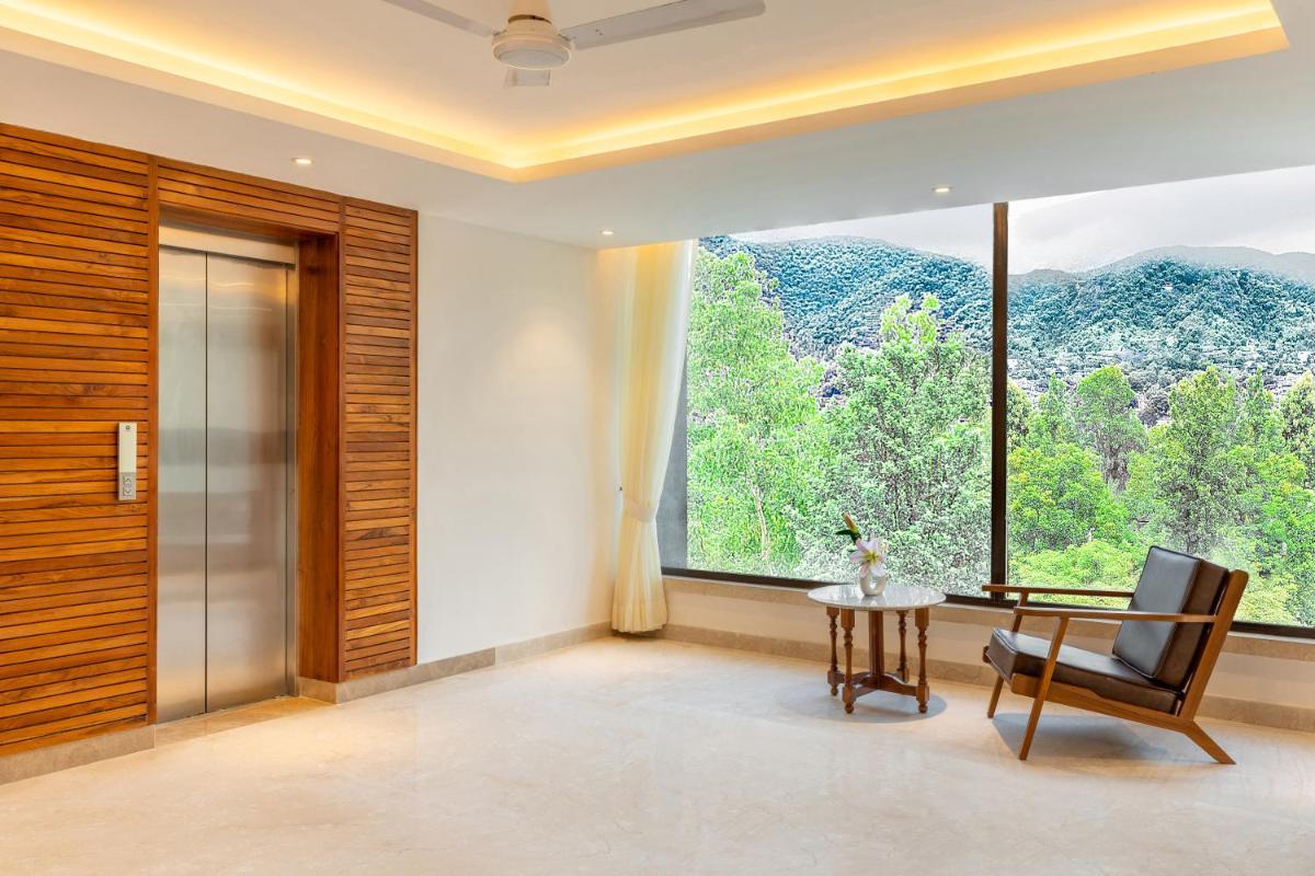 a dining room with a table and a large window at The Prominence Mussoorie Road Dehradun in Dehradun