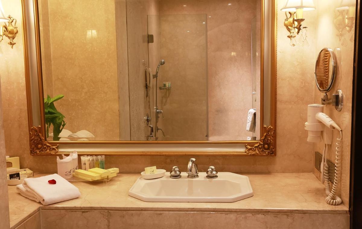 a bathroom with a sink and a large mirror at The Ashok, New Delhi in New Delhi a bathroom with a sink and a large mirror at The Ashok, New Delhi in New Delhi