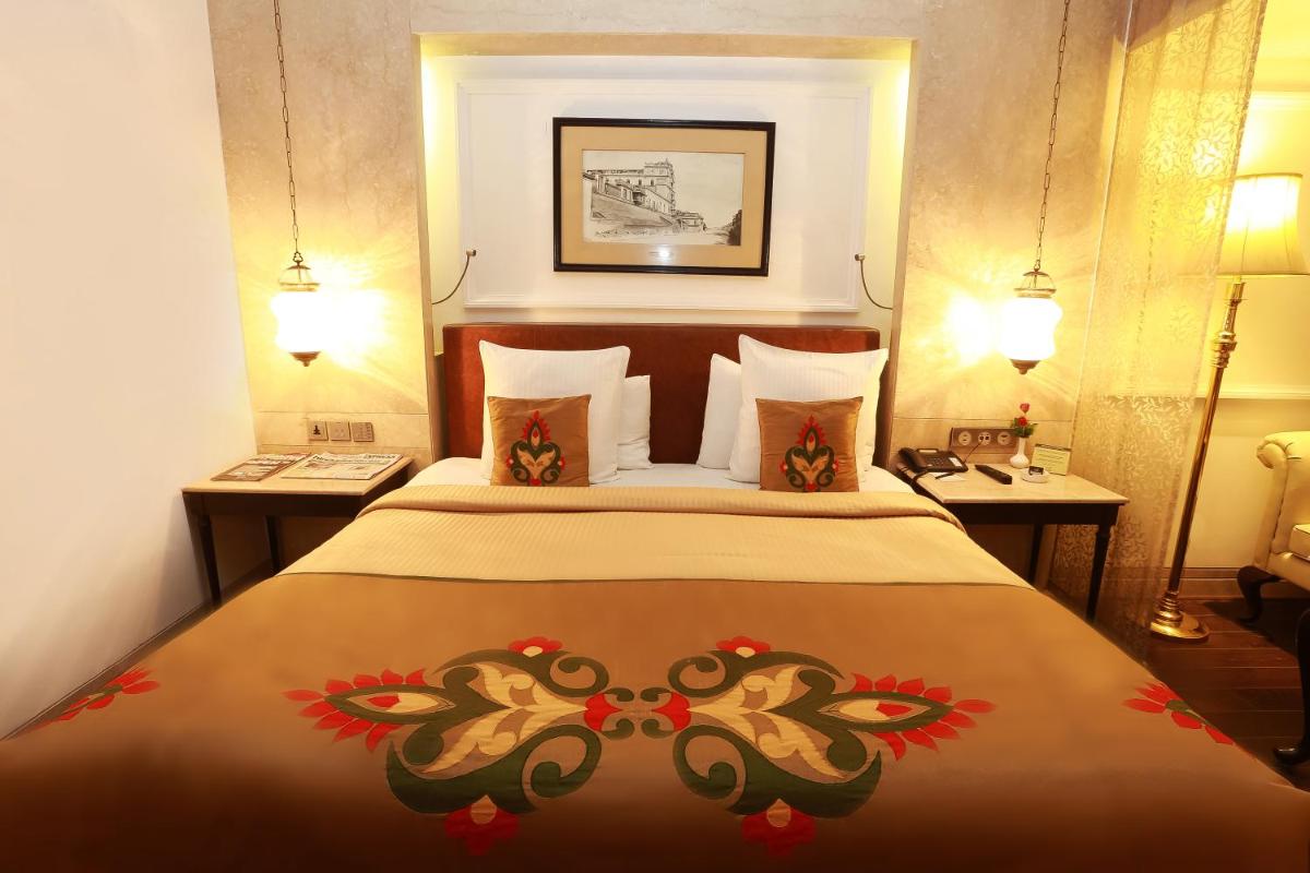 a bedroom with a large bed with flowers on it at The Ashok, New Delhi in New Delhi a bedroom with a large bed with flowers on it at The Ashok, New Delhi in New Delhi