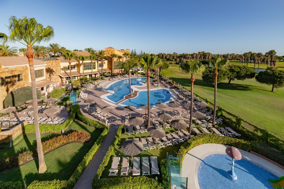 Una vista aérea de un resort con piscina y palmeras. en Elba Costa Ballena Beach & Thalasso Resort, en Costa Ballena