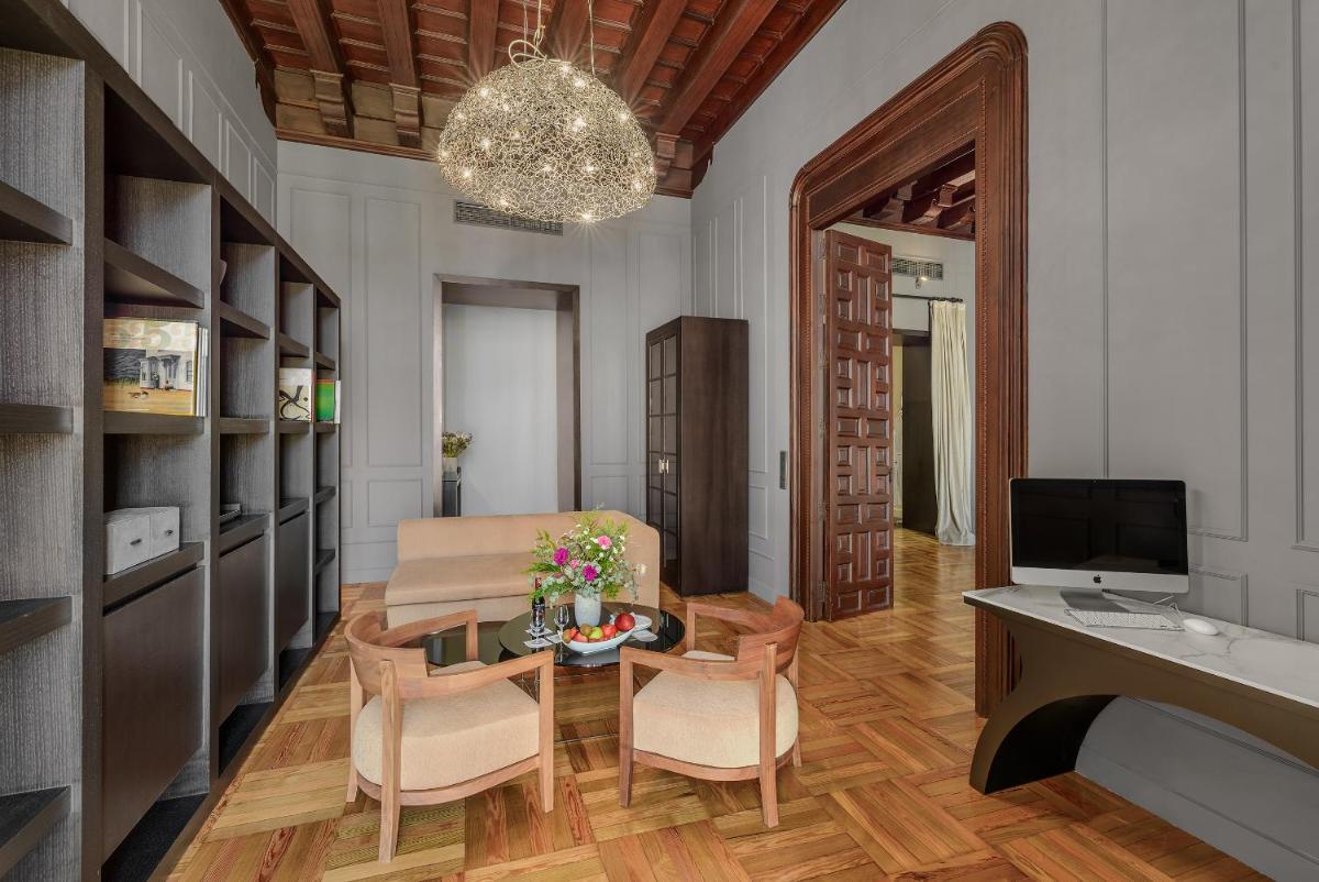 Una sala de estar con una mesa y sillas y un televisor. en CoolRooms Palacio Villapanés 5 GL, en Sevilla