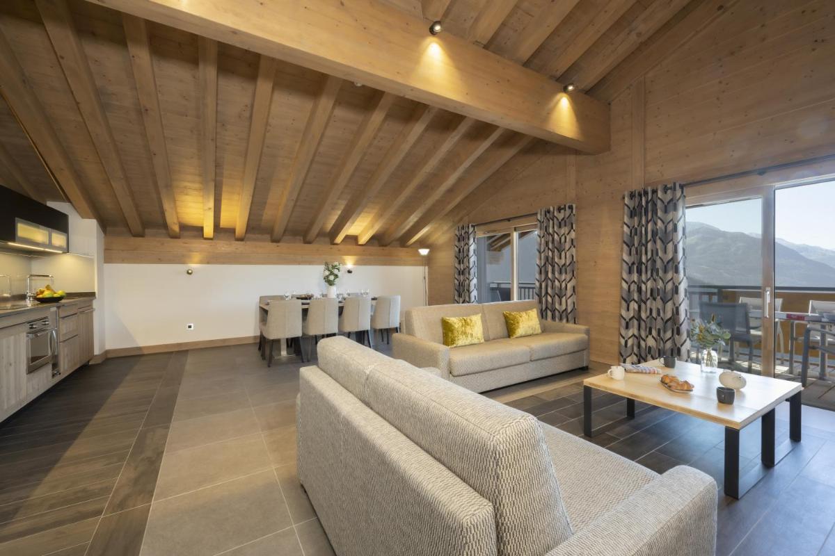 un salon avec un canapé et une table dans l'établissement MGM Hôtels & Résidences - Hôtel Alpen Lodge, à La Rosière