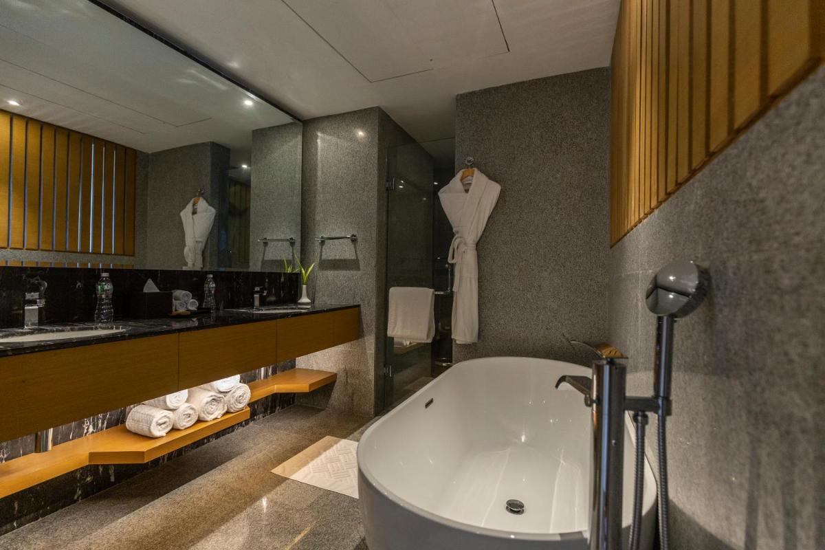 a bathroom with a bath tub and a sink at DoubleTree by Hilton Ahmedabad in Ahmedabad