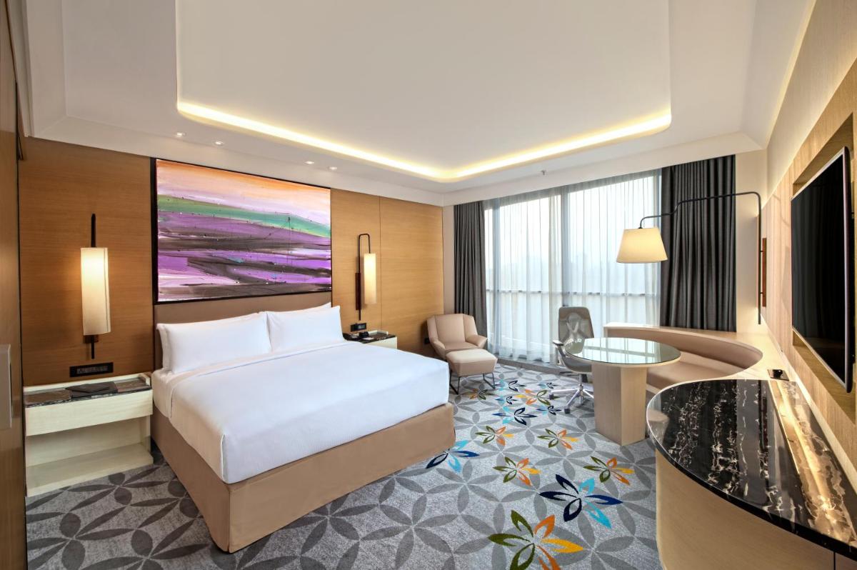 a hotel room with a bed and a desk at DoubleTree by Hilton Ahmedabad in Ahmedabad