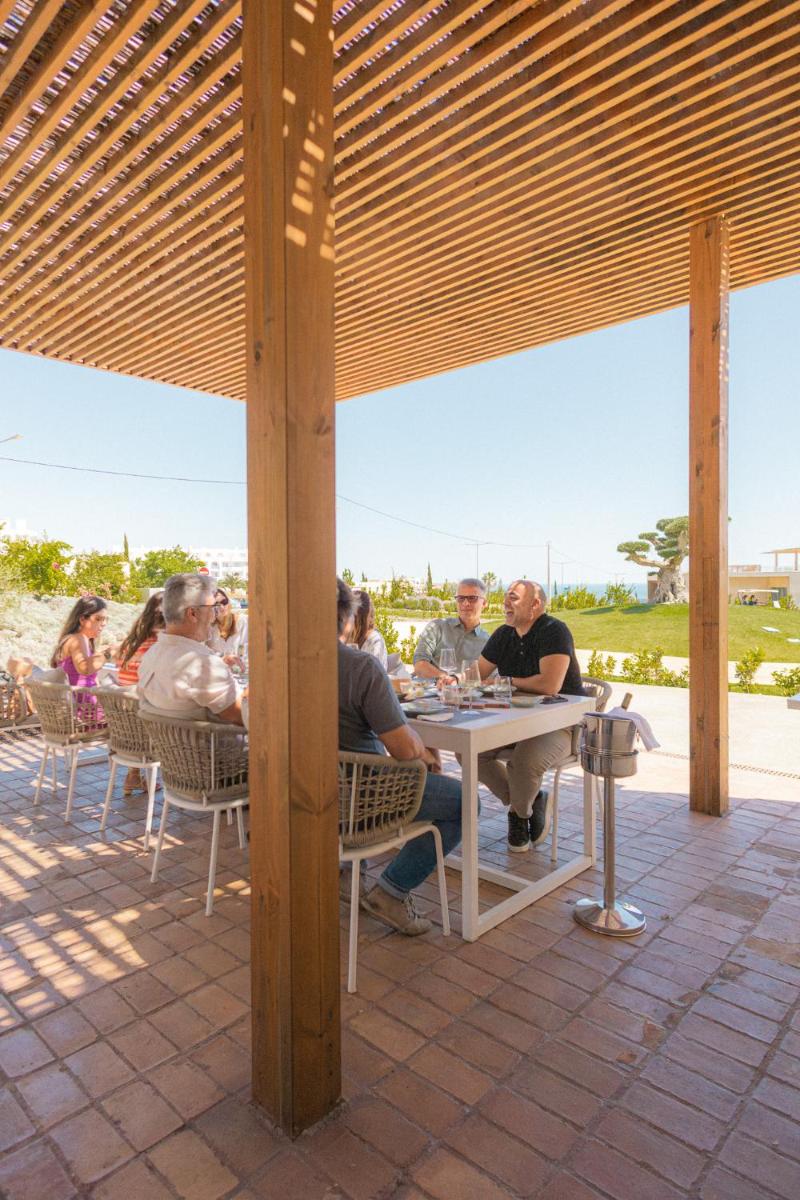 um grupo de pessoas sentadas numa mesa sob um pavilhão em White Shell Beach Villas em Porches mais 64 fotografias