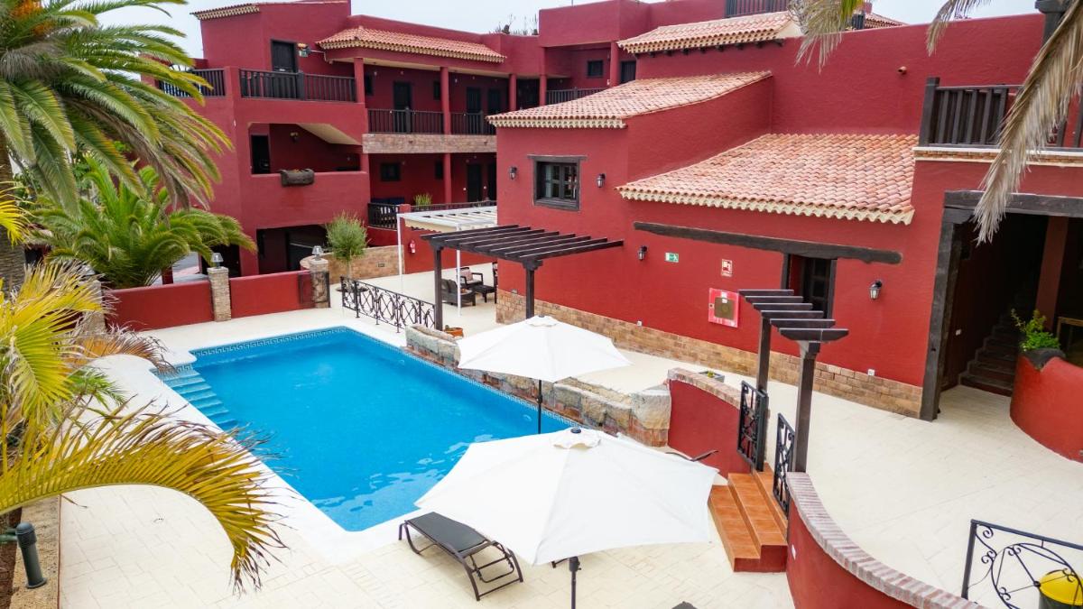 una vista exterior de un edificio con piscina y sombrillas en Hotel Ecolife Tenerife, en San Miguel de Abona
