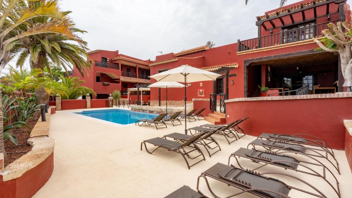 Un patio con tumbonas y una piscina. en Hotel Ecolife Tenerife, en San Miguel de Abona