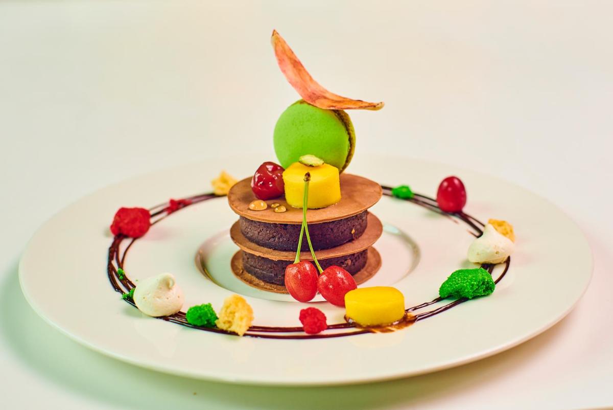 a plate with a stack of pancakes with fruit on top at Aloft Bengaluru Outer Ring Road in Bengaluru