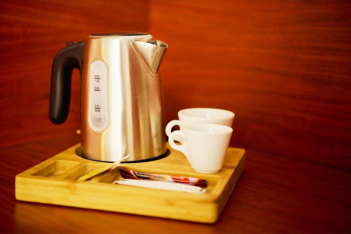 une cafetière et des tasses sur un plateau en bois dans l'établissement Sporting House Hôtel, à Toulouse