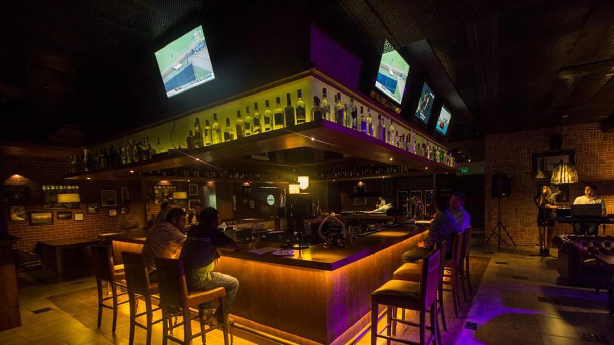 a bar in a pub with people sitting at it at The Oterra in Bengaluru