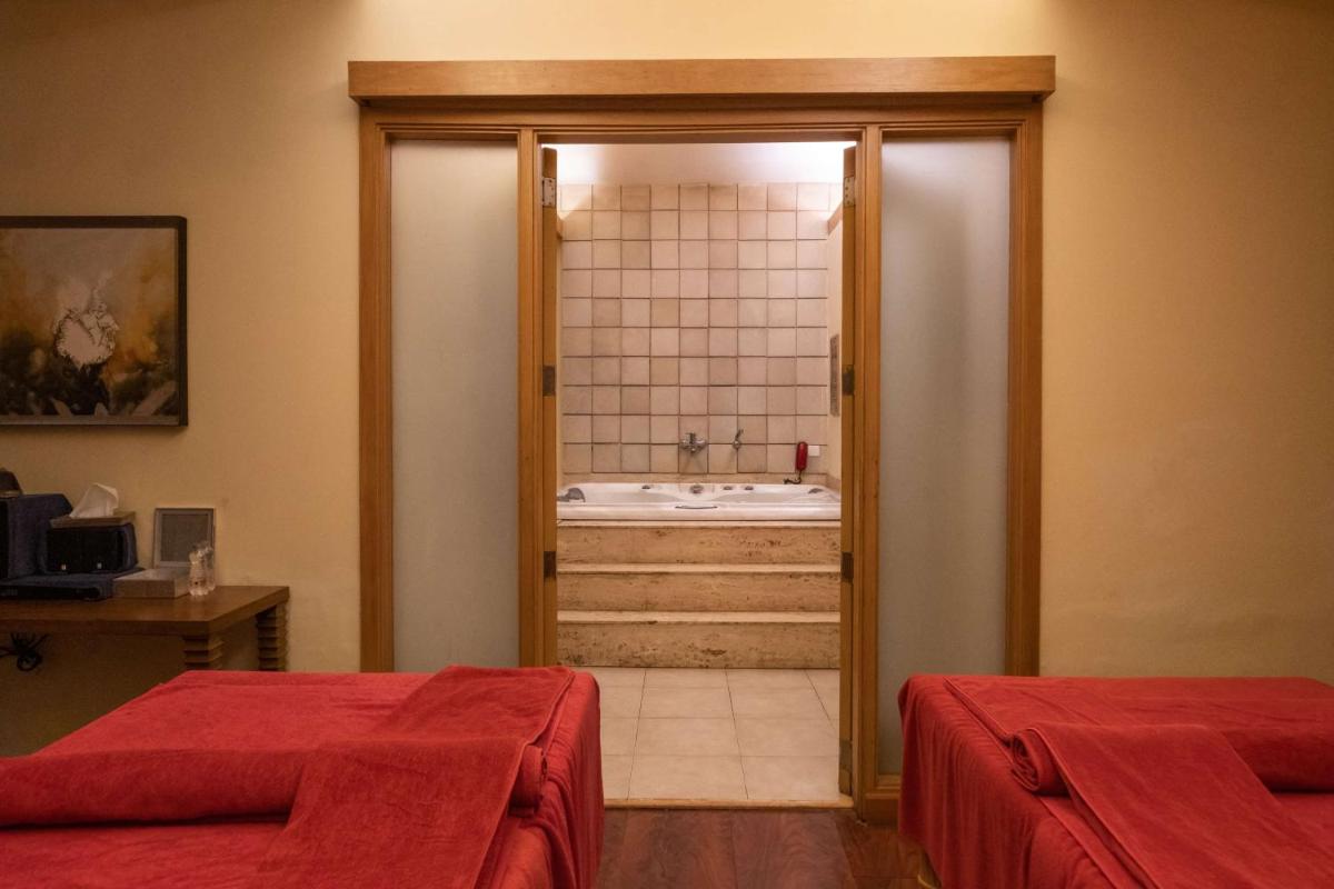 a bathroom with two beds and a bath tub at Radisson Blu Hotel, Indore in Indore