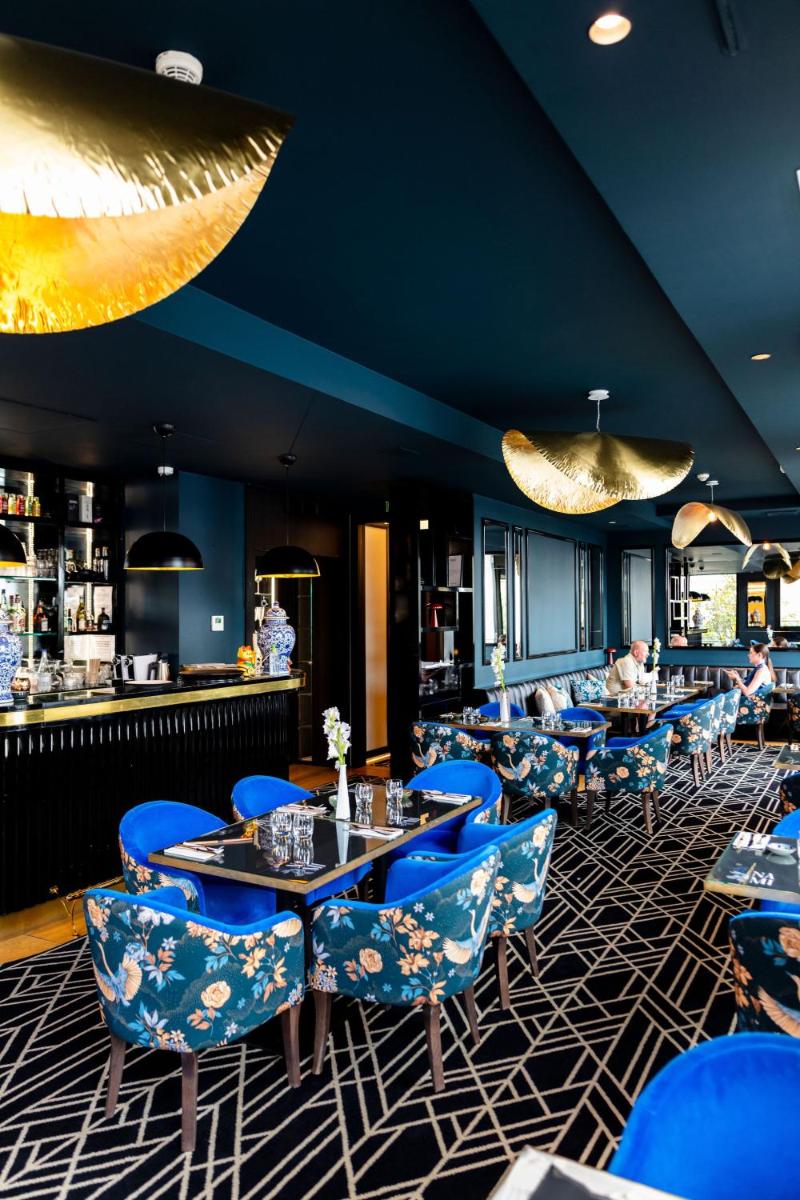 un restaurant avec des tables et des chaises bleues ainsi qu'un bar dans l'établissement Hôtel Restaurant le Touring - Teritoria, à Saint-Raphaël