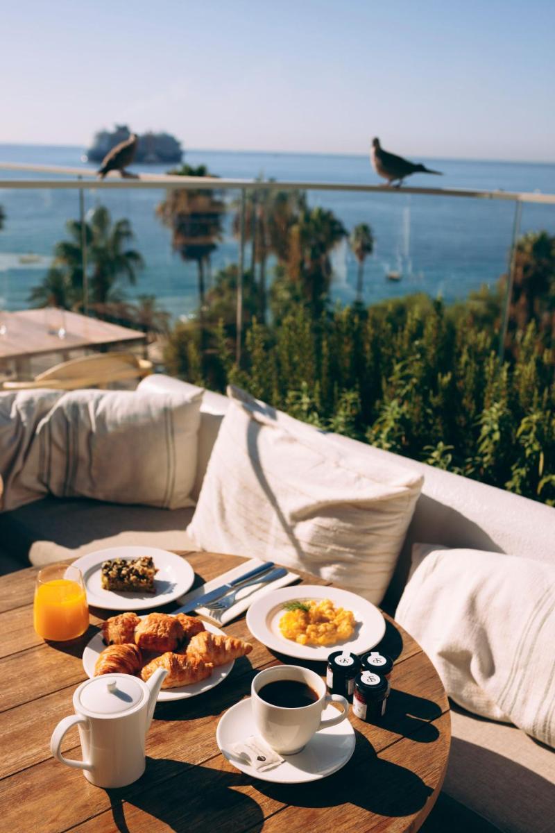 une table avec des assiettes de nourriture sur une table avec vue dans l'établissement Hôtel & Spa Belle Plage, à Cannes 37 autres photos