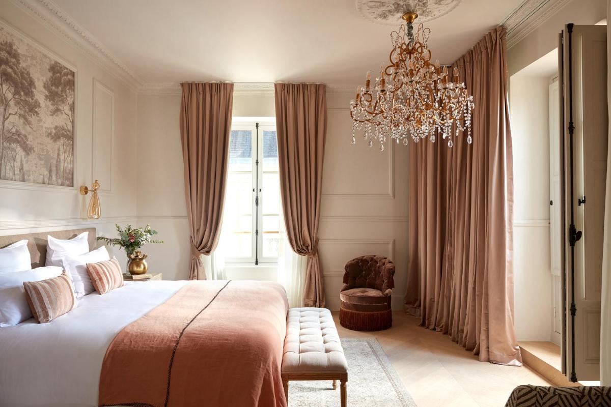 une chambre avec un grand lit et un lustre dans l'établissement Château Léognan, Domaine viticole - proche Bordeaux, à Léognan