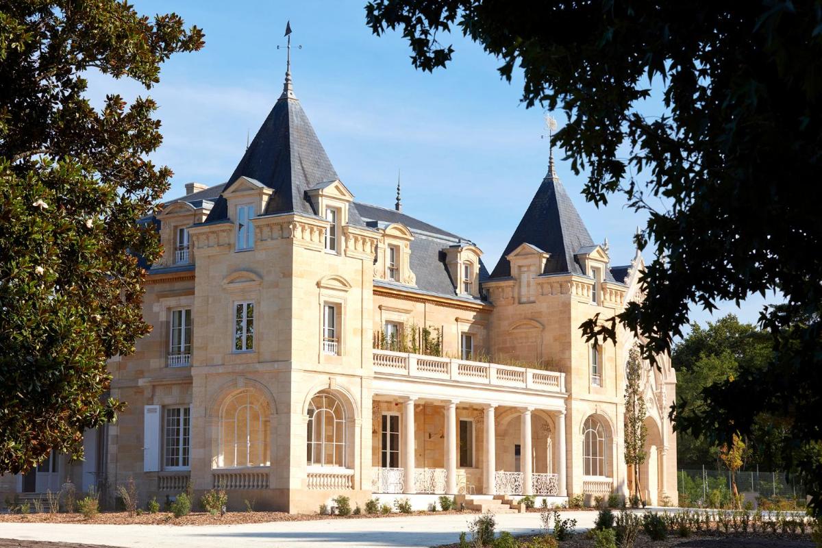 un grand bâtiment avec deux tours au sommet dans l'établissement Château Léognan, Domaine viticole - proche Bordeaux, à Léognan