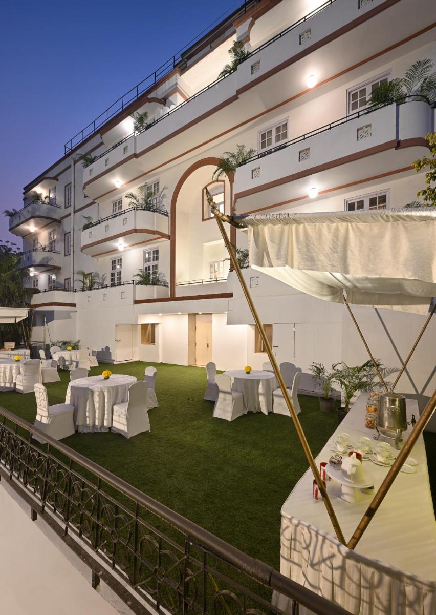 a building with a lawn with white tables and chairs at Ambassador, New Delhi - IHCL SeleQtions in New Delhi a building with a lawn with white tables and chairs at Ambassador, New Delhi - IHCL SeleQtions in New Delhi