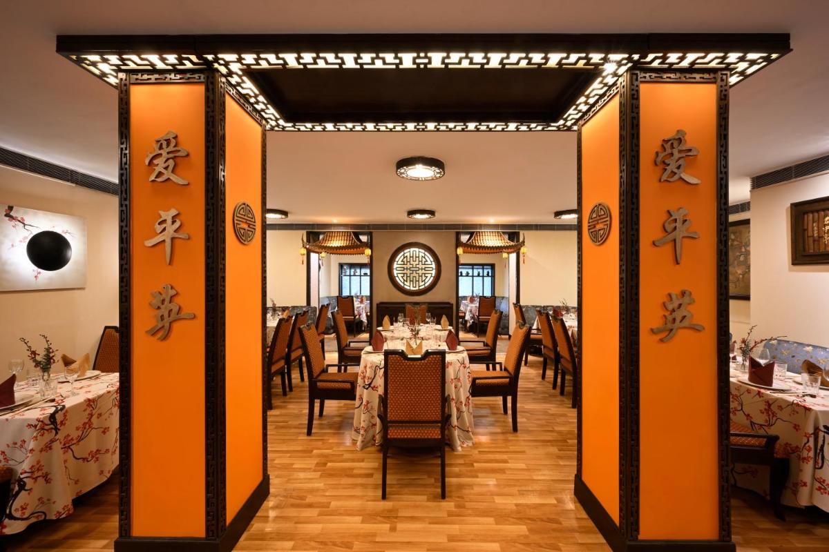 a dining room with a table and chairs at Ambassador, New Delhi - IHCL SeleQtions in New Delhi a dining room with a table and chairs at Ambassador, New Delhi - IHCL SeleQtions in New Delhi