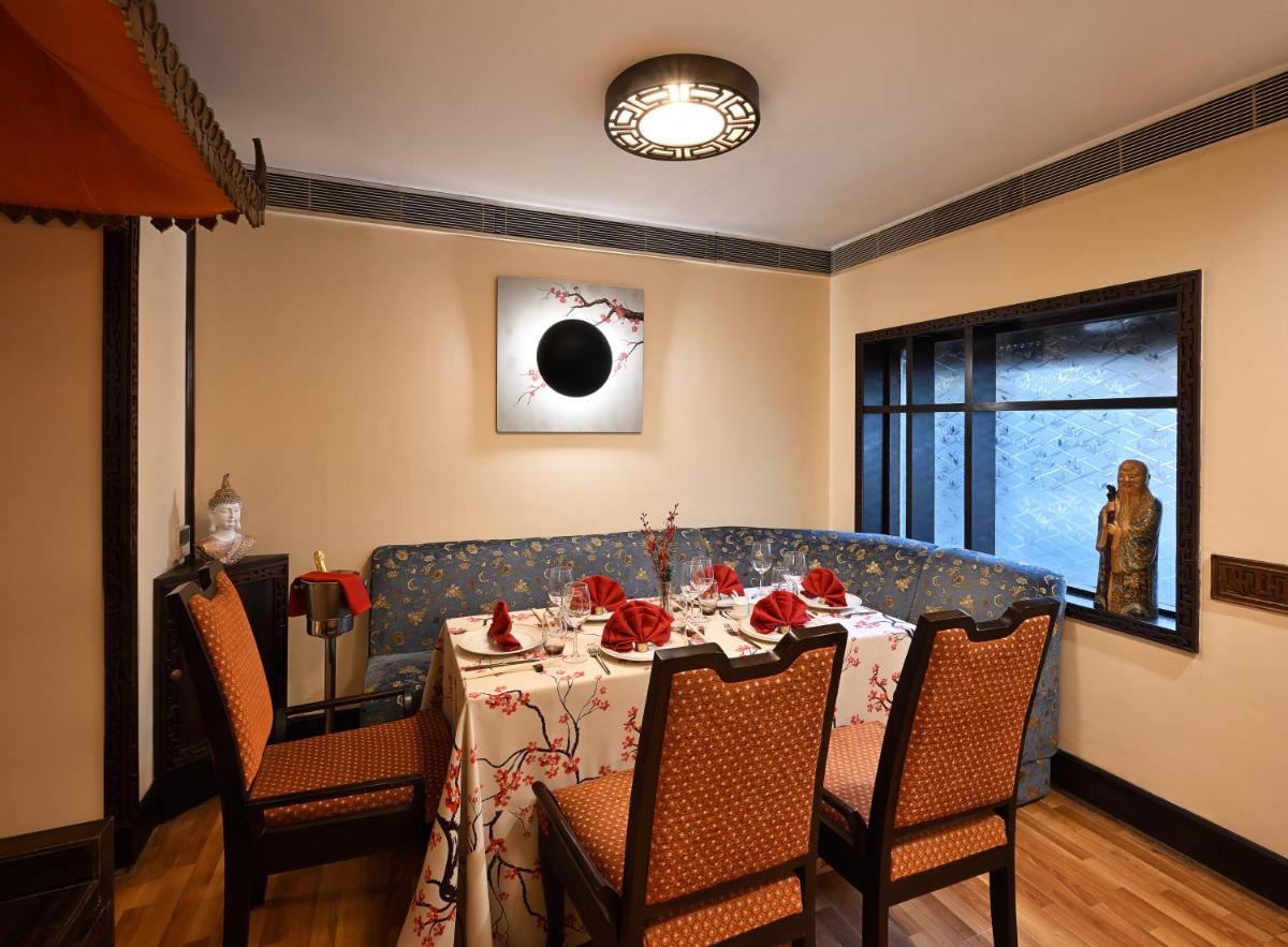 a dining room with a table with red roses on it at Ambassador, New Delhi - IHCL SeleQtions in New Delhi a dining room with a table with red roses on it at Ambassador, New Delhi - IHCL SeleQtions in New Delhi