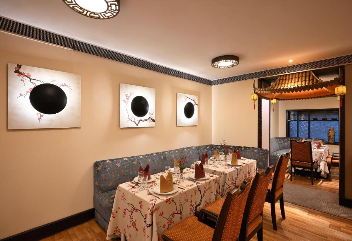 a dining room with a long table and chairs at Ambassador, New Delhi - IHCL SeleQtions in New Delhi a dining room with a long table and chairs at Ambassador, New Delhi - IHCL SeleQtions in New Delhi