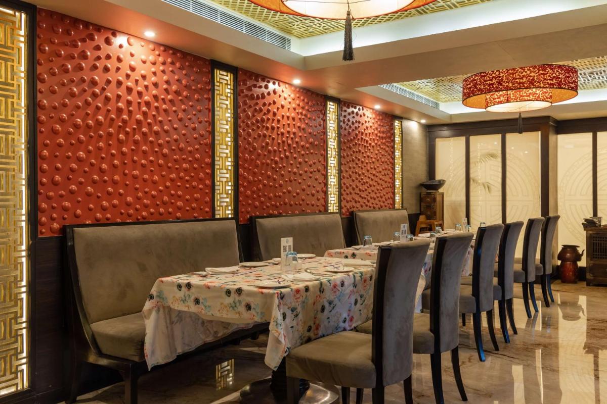 a dining room with a long table and chairs at Radisson Blu Hotel, Indore in Indore