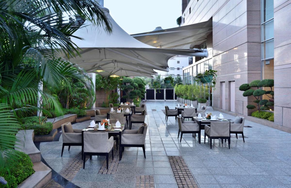 a restaurant with tables and chairs on a courtyard at Radisson Blu Hotel, Indore in Indore