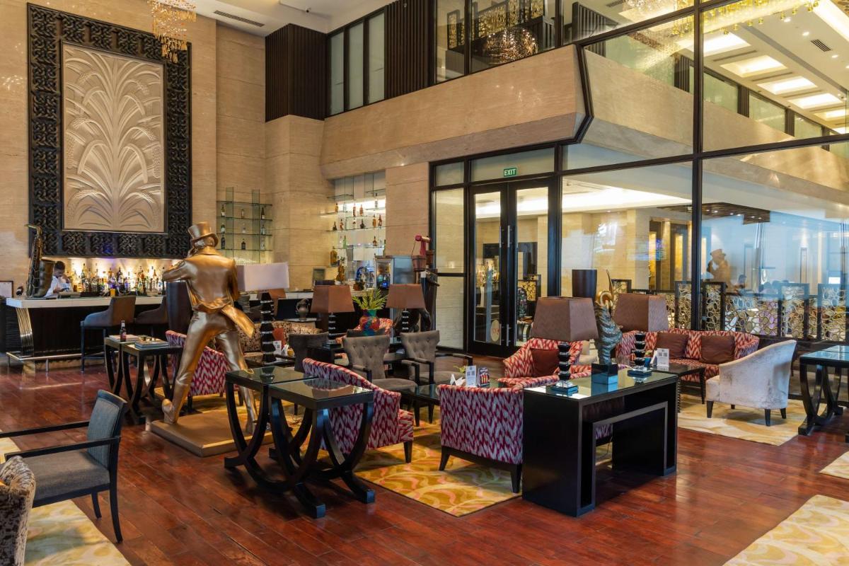 a lobby of a hotel with tables and chairs at Radisson Blu Hotel, Indore in Indore