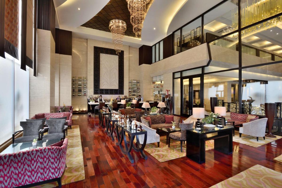 a hotel lobby with tables and couches at Radisson Blu Hotel, Indore in Indore