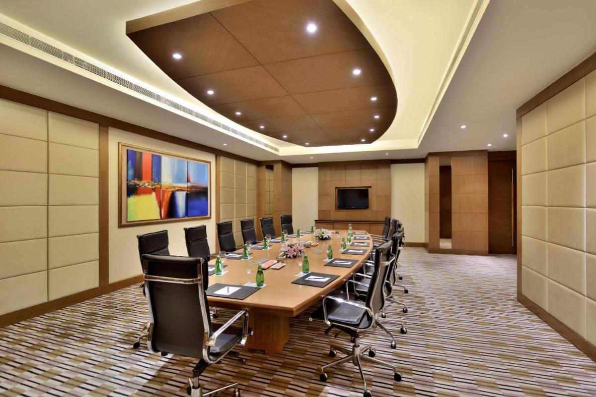 a large conference room with a long table and chairs at Radisson Blu Hotel, Indore in Indore