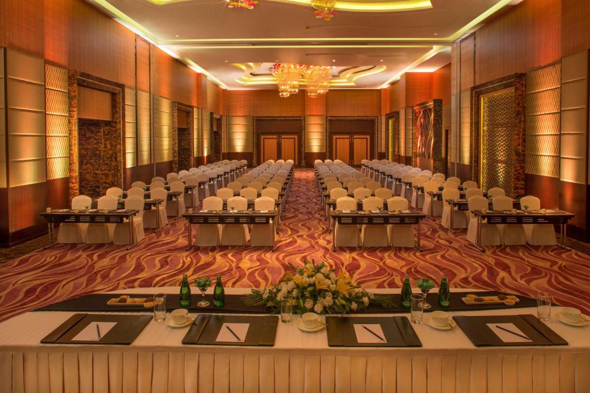 a banquet hall with tables and chairs in a room at Radisson Blu Hotel, Indore in Indore