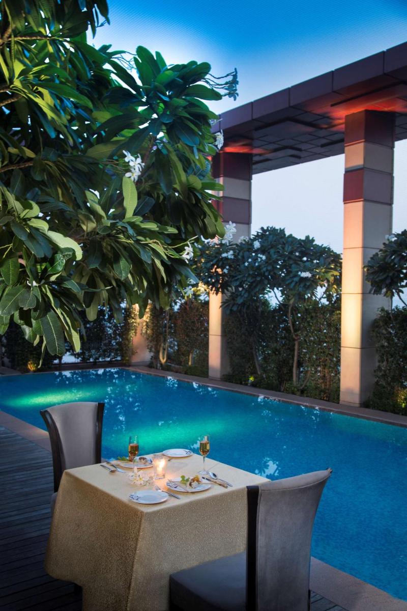 a table in a restaurant next to a swimming pool at Radisson Blu Hotel, Indore in Indore