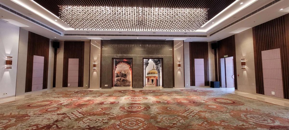 a large hall with a chandelier and a large rug at Radisson Blu Hotel, Greater Noida in Greater Noida