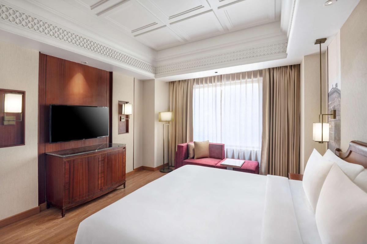 a hotel room with a bed and a flat screen tv at Radisson Kufri in Shimla