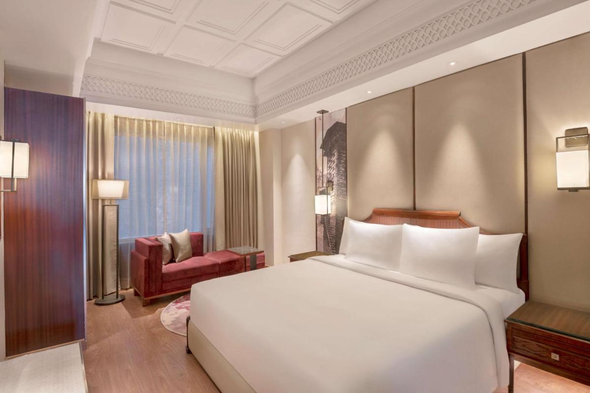 a bedroom with a large white bed and a chair at Radisson Kufri in Shimla