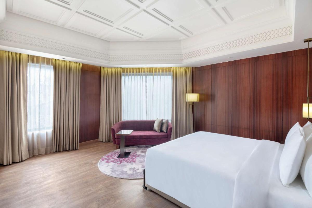 a bedroom with a large white bed and a chair at Radisson Kufri in Shimla