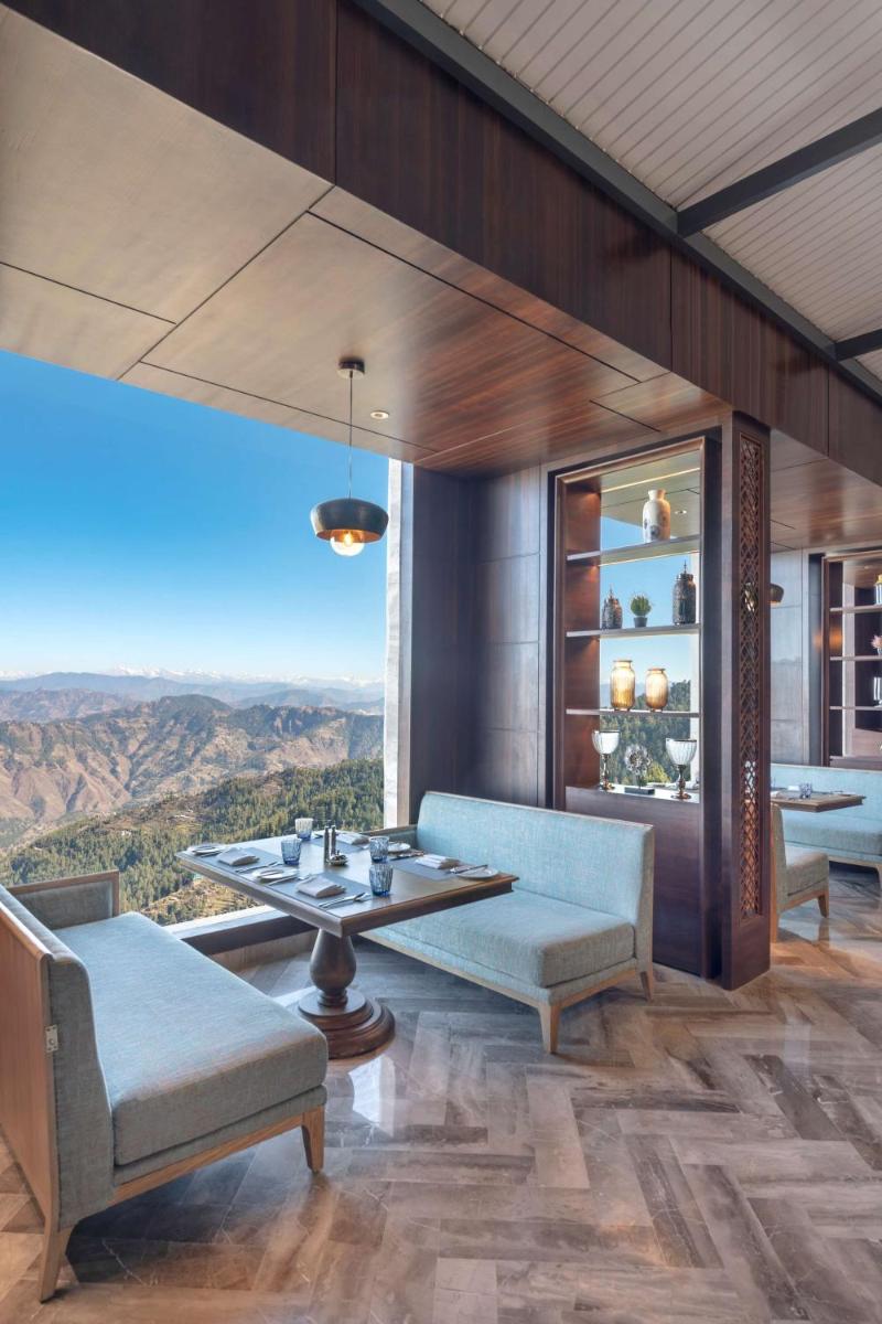 a dining room with a table and chairs and a view at Radisson Kufri in Shimla