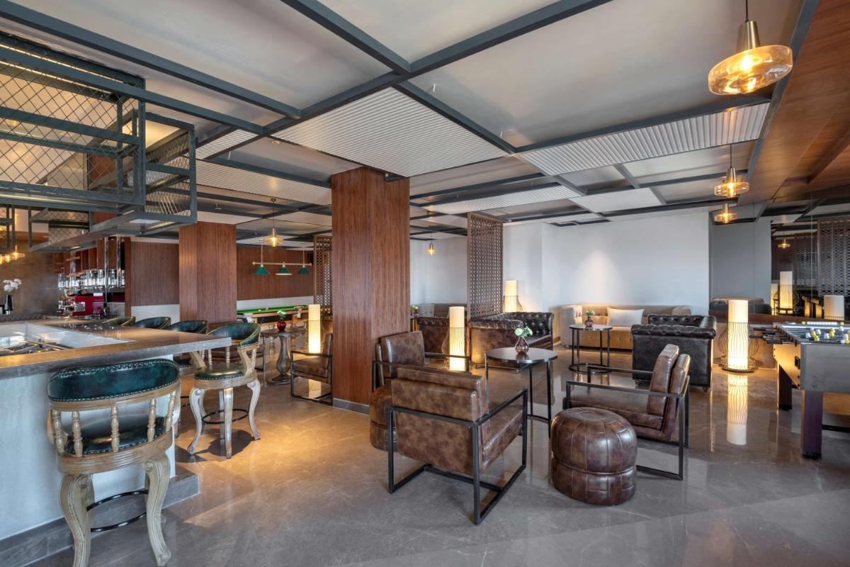 a lobby with tables and chairs and a bar at Radisson Kufri in Shimla