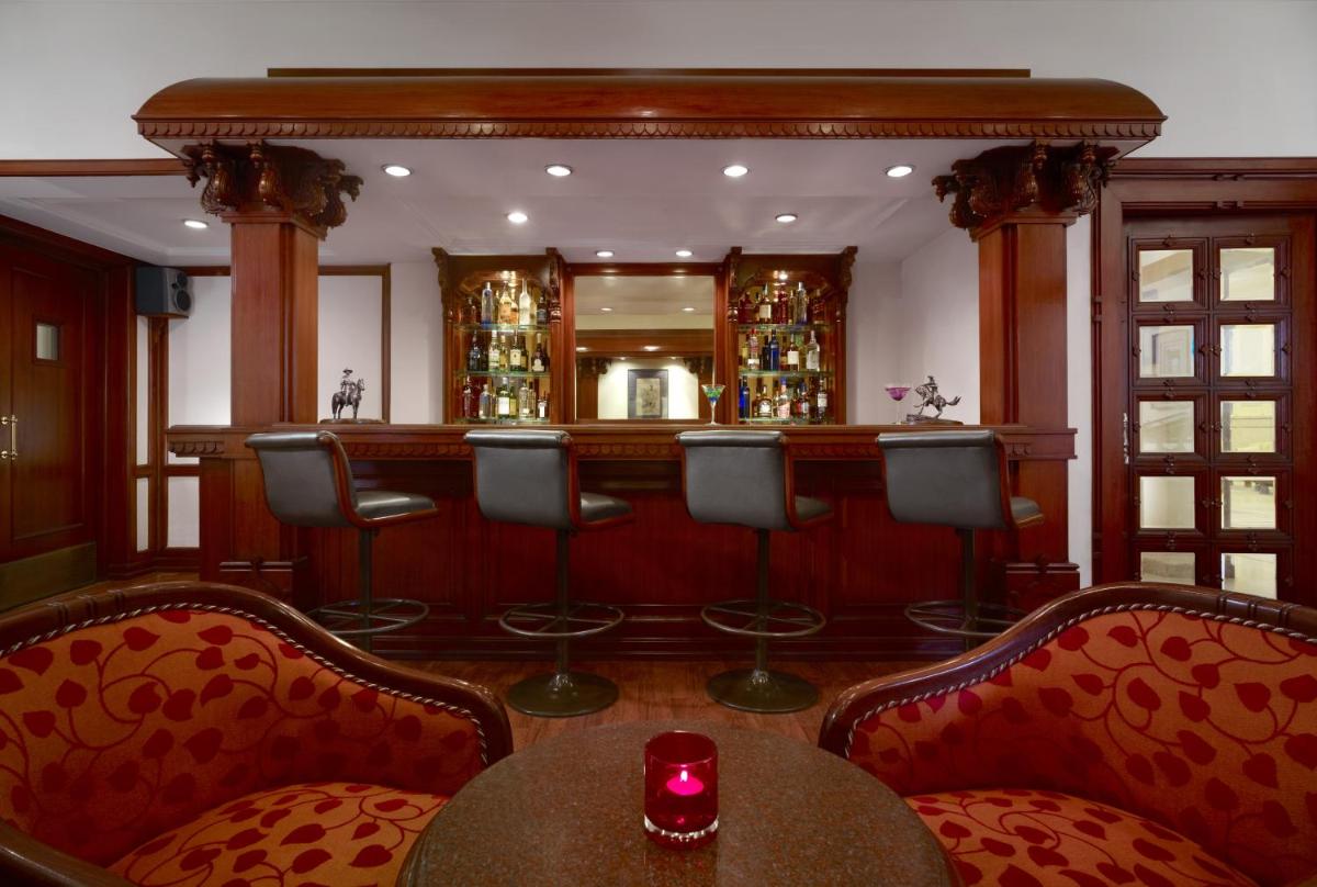 a bar with chairs and a table with a red candle at Taj Ganges Varanasi in Varanasi