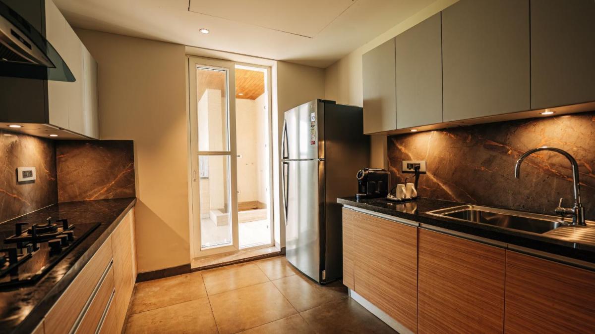 a kitchen with a sink and a refrigerator at Holiday Inn Goa Candolim in Candolim a kitchen with a sink and a refrigerator at Holiday Inn Goa Candolim in Candolim