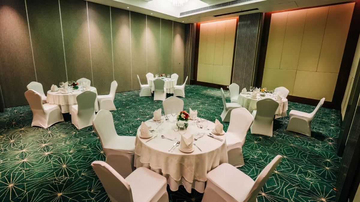 a banquet room with white tables and white chairs at Holiday Inn Goa Candolim in Candolim a banquet room with white tables and white chairs at Holiday Inn Goa Candolim in Candolim