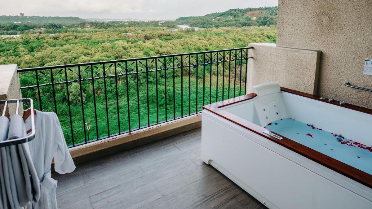 a room with a bath tub on a balcony at Holiday Inn Goa Candolim in Candolim a room with a bath tub on a balcony at Holiday Inn Goa Candolim in Candolim