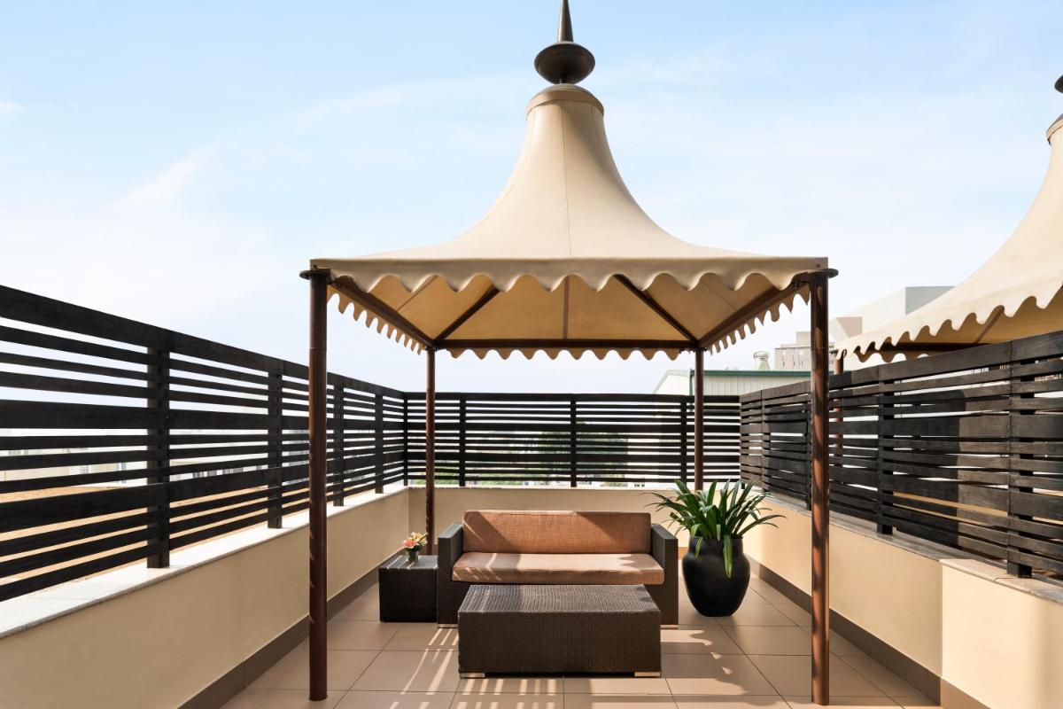 a balcony with a gazebo and a bench at Hilton Jaipur in Jaipur a balcony with a gazebo and a bench at Hilton Jaipur in Jaipur