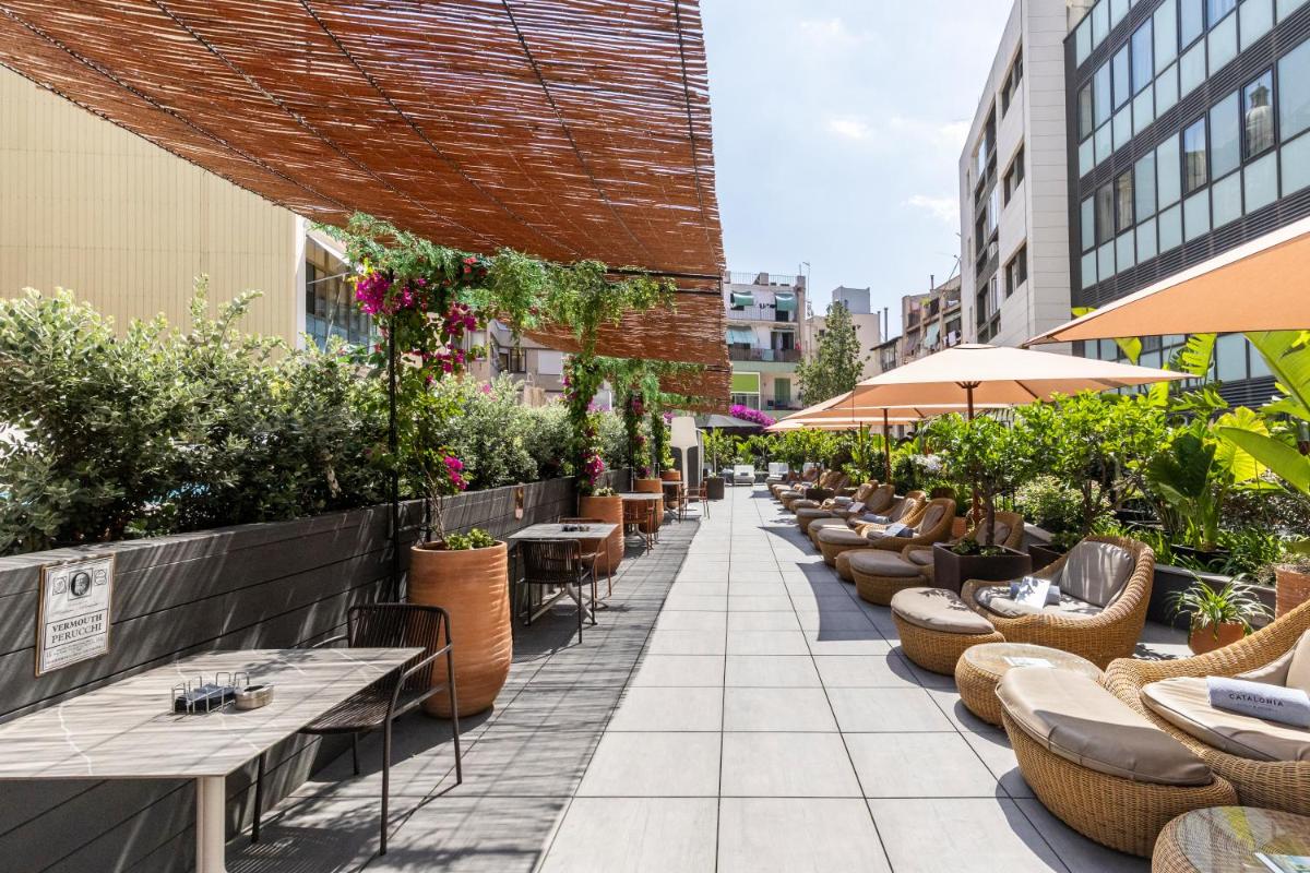 Un patio al aire libre con mesas, sillas y plantas. en Catalonia Ramblas 4* Sup, en Barcelona