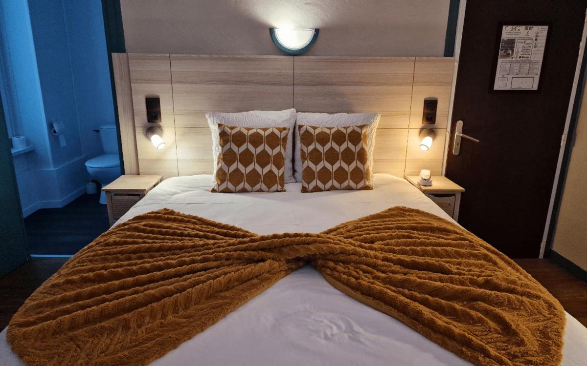 Un ou plusieurs lits dans un hébergement de l'établissement Logis Central Hôtel - Restaurant & Spa