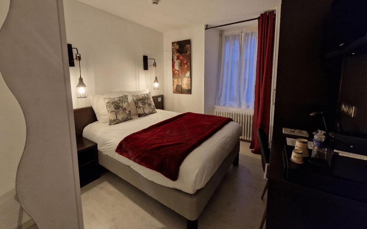 une chambre avec un lit et une fenêtre dans l'établissement Logis Central Hôtel - Restaurant & Spa, à Bort-les-Orgues