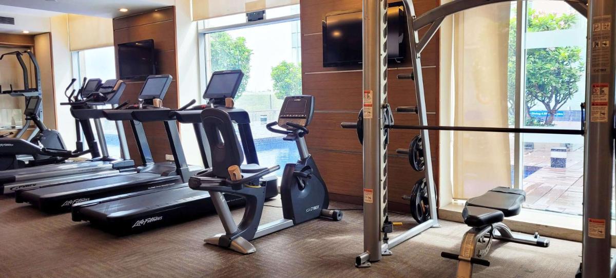 a gym with a bunch of tread machines in a room at Radisson Blu Hotel, Greater Noida in Greater Noida