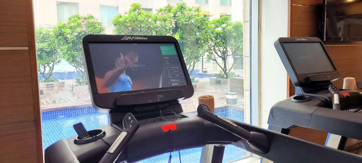 a monitor on a exercise bike with a window at Radisson Blu Hotel, Greater Noida in Greater Noida
