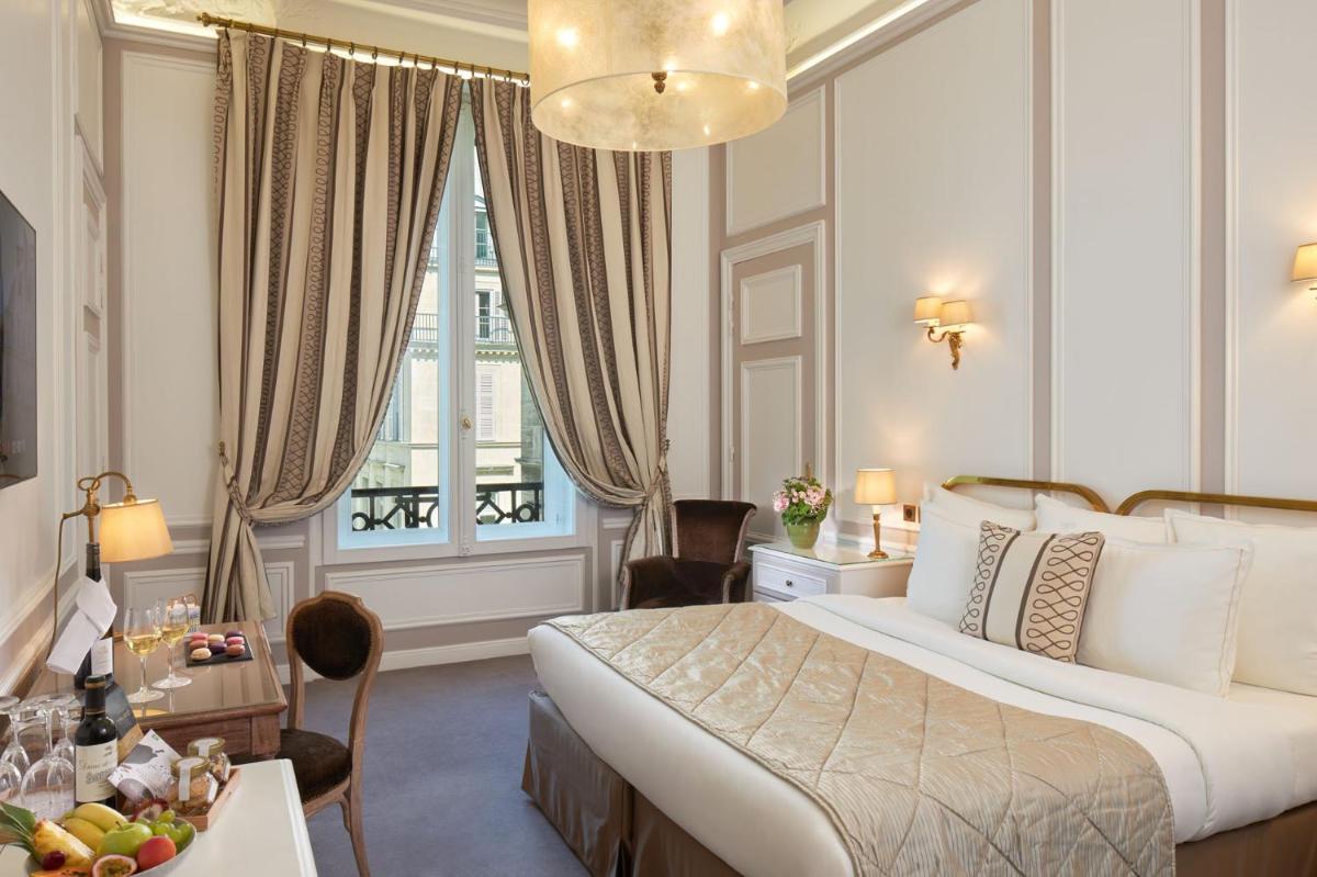 Cette chambre comprend un grand lit et une table avec des fruits. dans l'établissement Hôtel Regina Louvre, à Paris