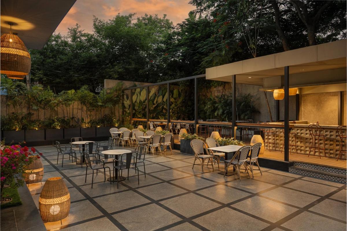 a group of tables and chairs on a patio at Grand Mercure Bangalore - An Accor Brand in Bengaluru