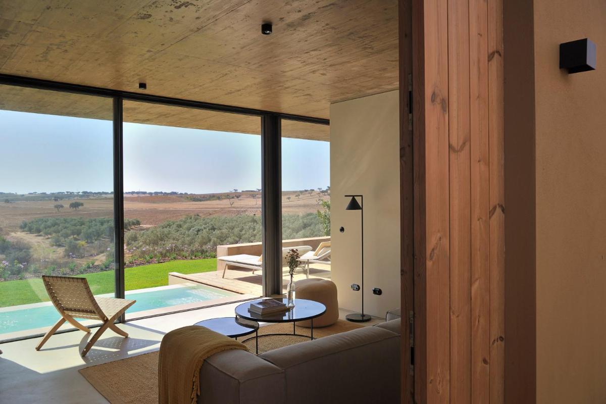uma sala de estar com um sofá e uma mesa em Herdade da Malhadinha Nova - Relais & Châteaux em Albernoa